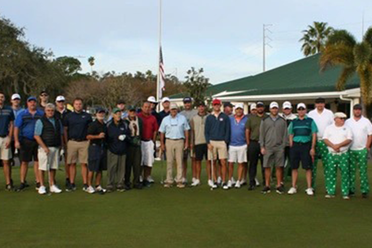 view of gathering on green by clubhouse posed for a group photo
